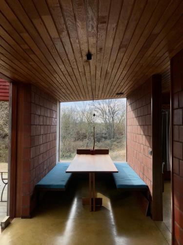 a room with a table and benches in a room with a window at rodune in Koksijde