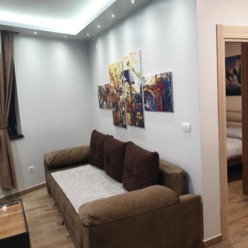 a living room with a couch and paintings on the wall at Apartman Noalux Kopaonik in Kopaonik