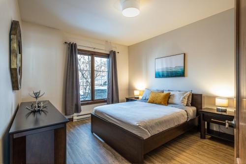 a bedroom with a bed and a window at Le Sous-Bois (Les Manoirs) Mont-Tremblant in Mont-Tremblant