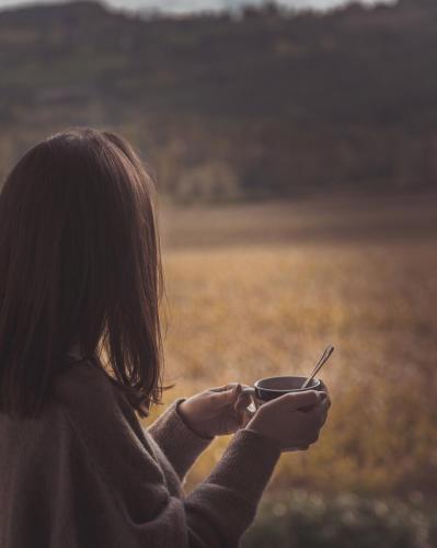 a woman holding a bowl with a spoon in her hand at Agriturismo Querceto in Frazione Mocaiana
