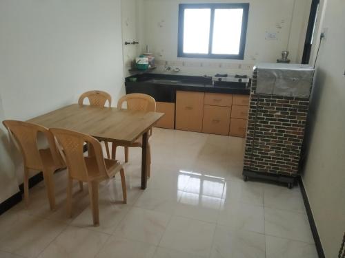 a kitchen with a wooden table and chairs and a sink at Rutugandh Homestay in Wai