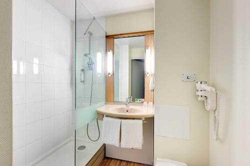 a bathroom with a sink and a shower at Ibis Agen Centre Gare in Agen