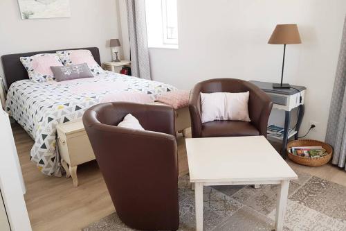 a bedroom with two chairs and a bed at Studio Cosy LES ROSES TREMIERES 3 étoiles centre Plouharnel proche mer in Plouharnel