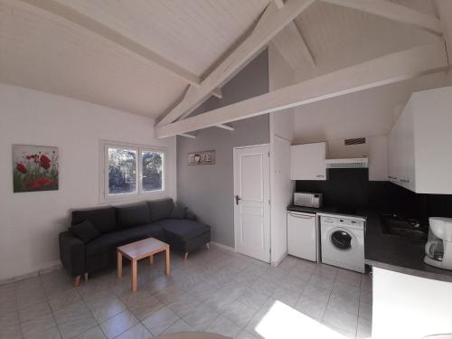 un salon avec un canapé et une cuisine dans l'établissement Appartement SOULAC SUR MER À 500 m de la plage N 1, à Soulac-sur-Mer