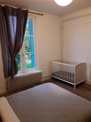 ein Babyzimmer mit einem Kinderbett und einem Fenster in der Unterkunft Appartement 80m2 dans belle demeure in Vrigne-aux-Bois