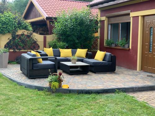 a patio with a black couch and yellow pillows at Agro na Wapniarni in Białla