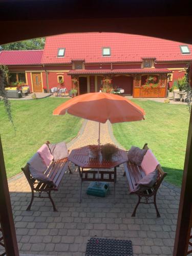 a table and chairs with an umbrella on a patio at Agro na Wapniarni in Białla