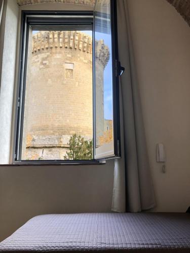 a bedroom with a window with a brick building at Dimora Sole Raggiante in Venosa