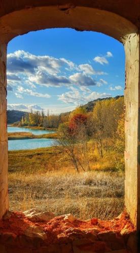 a view of a field from an old window at Casas Rurales Lagunas de Ruidera II in Ossa de Montiel