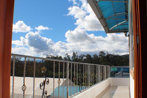 a balcony with a view of a swimming pool at Hotel Las Palmeras Gachancipa in Gachancipá