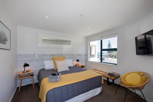 um quarto com uma cama e uma janela em Ocean Retreat 228 em Mount Maunganui