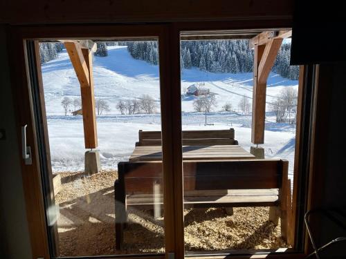 a window with a view of a snow covered yard at Gîte avec terrasse et belle vue - ChaletNelda com in Lamoura