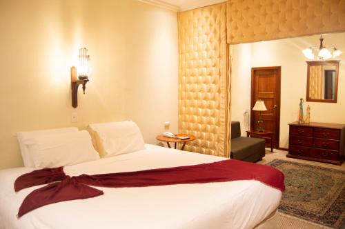 a bedroom with a large white bed in a room at Hotel Carvallo in Cuenca