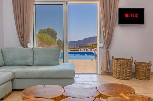 a living room with a couch and two tables at Lindos Villa Agape in Líndos