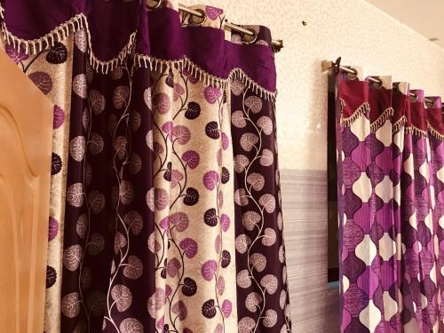 a pair of black and purple curtains on a wall at Rehoboth Home Stay in Kanyakumari