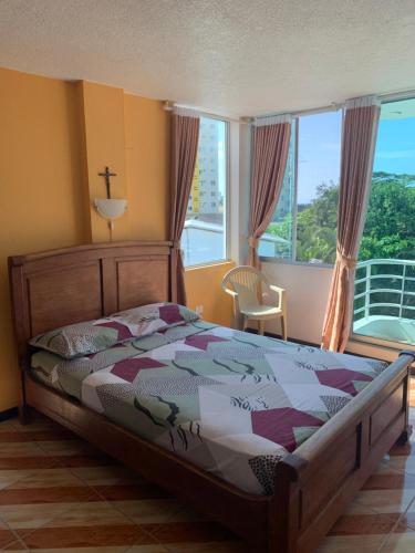 a bedroom with a bed and a large window at Hotel Kemarios in Tonsupa