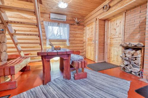 a log cabin with a table and a fireplace at Valkla Puhkekeskuse saunamaja in Kuusalu