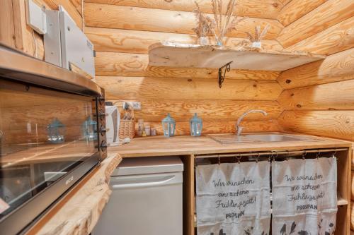 a kitchen with a sink and a stove at Valkla Puhkekeskuse saunamaja in Kuusalu