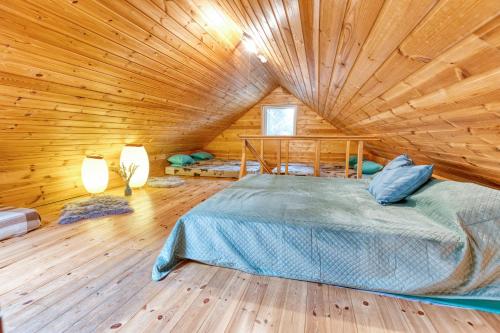 a bedroom with a bed in a wooden cabin at Valkla Puhkekeskuse saunamaja in Kuusalu