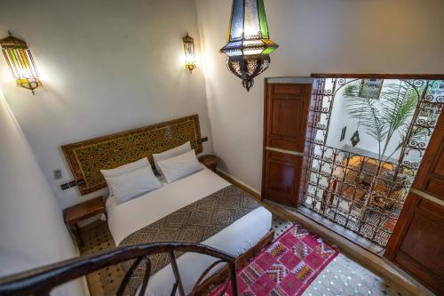 a bedroom with a bed and a window at Le cèdre d'argent in Fez