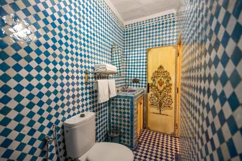 a bathroom with blue and white tiled walls and a toilet at Le Cèdre D'argent in Fès