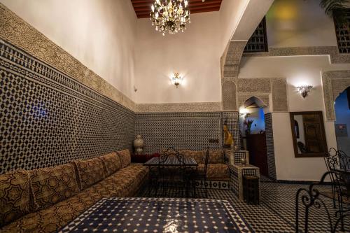 a living room with a couch and a chandelier at Le Cèdre D'argent in Fès
