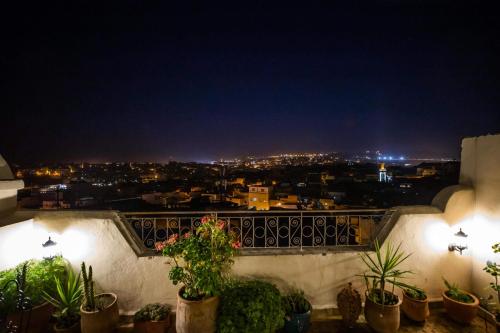 a view of a city at night from a balcony at Le Cèdre D'argent in Fès