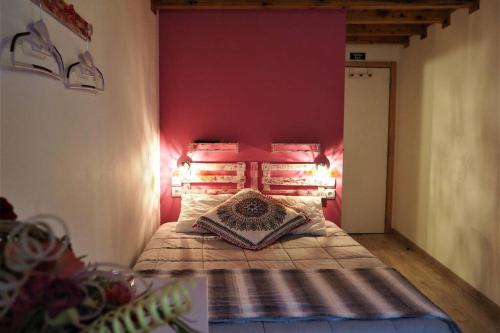 - une chambre dotée d'un lit avec un mur rouge dans l'établissement Casa D'Avó- Serra da Estrela, à Sameiro