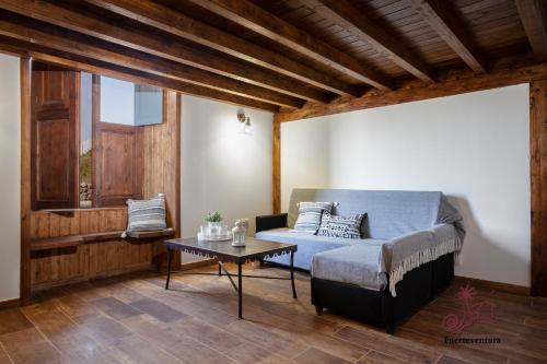 uma sala de estar com uma cama e uma mesa em Casa Emblemática "Casa del Cuartel" em La Oliva