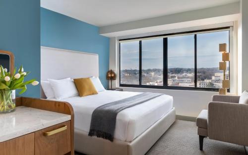 a bedroom with a bed and a large window at Hotel Madera in Washington