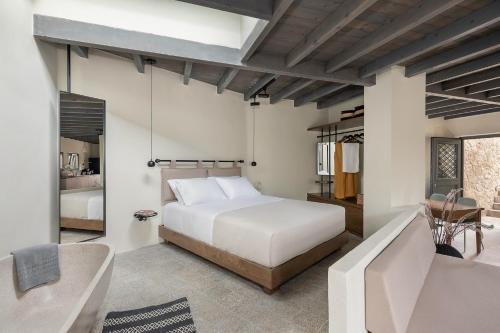 Velanis Ηouse, style into nature - secluded في كيساموس: غرفة نوم بسرير ابيض واريكة