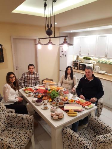 a group of people sitting around a table with food at Apartments Exclusive in Belgrade