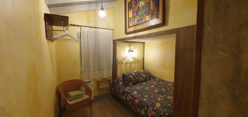 クエンカにあるCuencaloft Casa Azafranes VUTの小さなベッドルーム(ベッド1台、椅子付)
