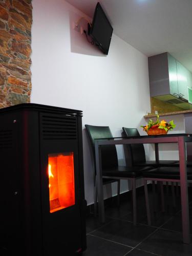 a room with a fireplace next to a table with a dining room at Casa D'Avó- Serra da Estrela in Sameiro