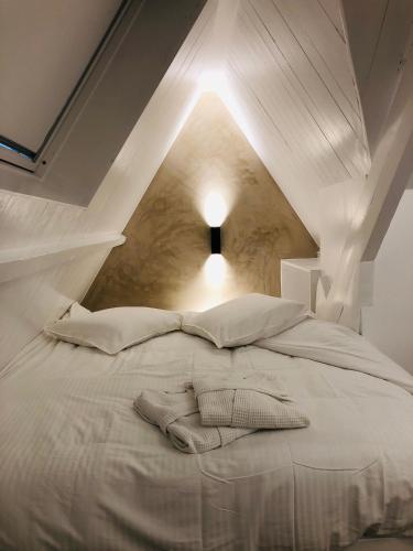 een wit bed met twee kussens erop bij Suites Le Porte-Bonheur in Brugge