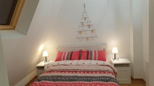 Schlafzimmer mit einem Bett mit roten Kissen und einem Kronleuchter in der Unterkunft Apartman Mladenovic Divcibare in Divčibare