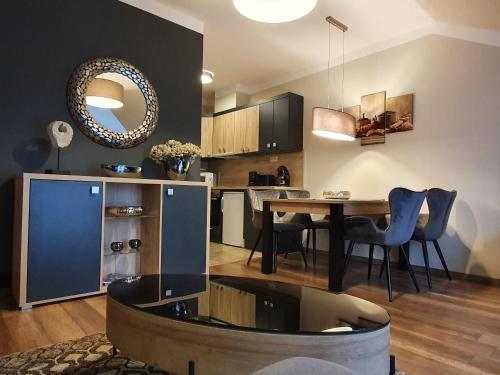 a kitchen and dining room with a table and chairs at Birdland Panorama Apartman in Bük