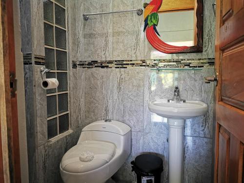 La salle de bains est pourvue de toilettes et d'un lavabo. dans l'établissement Tuki Tuki Lodge, à Sámara