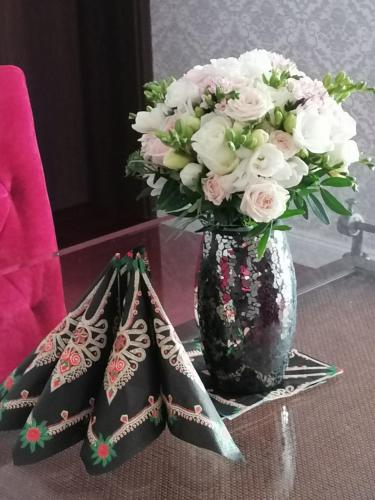 a vase with a bouquet of flowers on a table at Villa Zdrojowa in Otmuchów