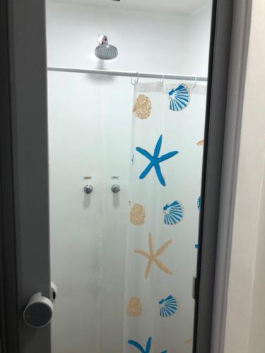 einen Duschvorhang mit Muscheln im Bad in der Unterkunft Flat Angra Inn 220 Angra dos Reis in Angra dos Reis