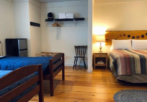 a bedroom with two beds and a desk and a chair at Trailside Inn in Killington