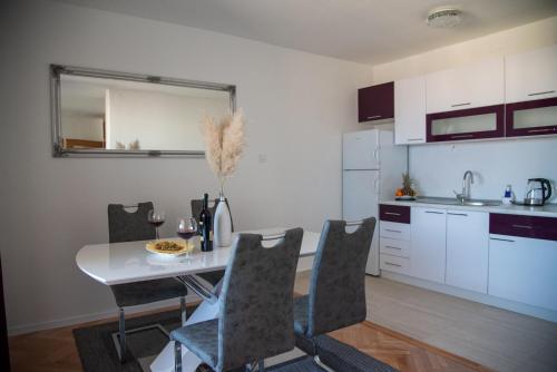 a kitchen and dining room with a table and chairs at Apartman Ante in Livno