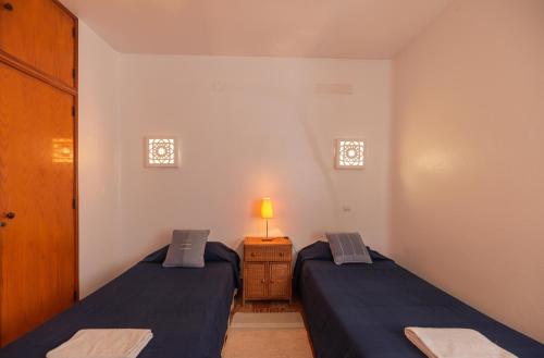 1 dormitorio con 2 camas y mesita de noche con lámpara en Tio Papel IV, en Albufeira
