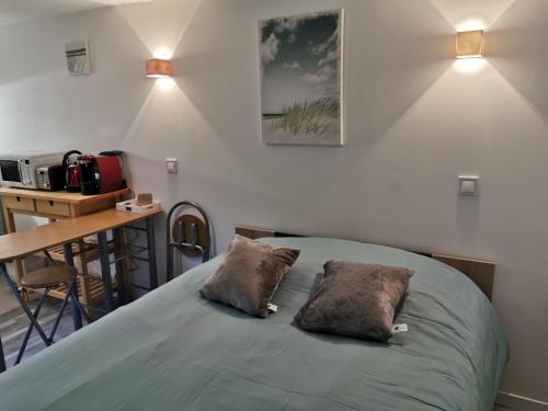 une chambre avec un lit avec deux oreillers dessus dans l'établissement La petite cour, à Honfleur