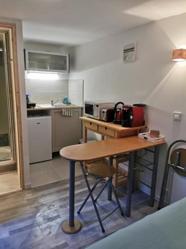 une petite cuisine avec une table et un micro-ondes dans l'établissement La petite cour, à Honfleur