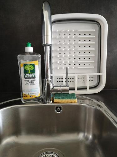 a sink with a bottle of cleaning detergent next to it at L6 - Green and premium flat close Paris - WIFI & NETFLIX in Longjumeau