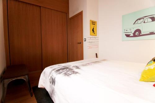 um quarto com uma cama branca e uma porta de madeira em Las tres Biznagas em Málaga