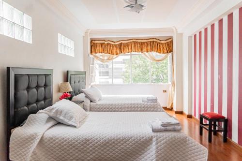 a bedroom with two beds and a window at Residencial Velia & Victoria in Cochabamba