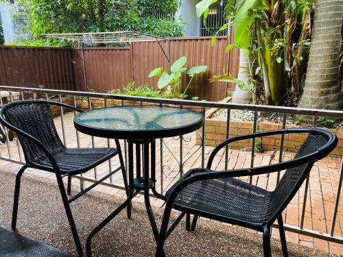 una mesa de patio con 2 sillas y una mesa con sillas en Quiet family Townhouse in Wollongong CBD en Wollongong