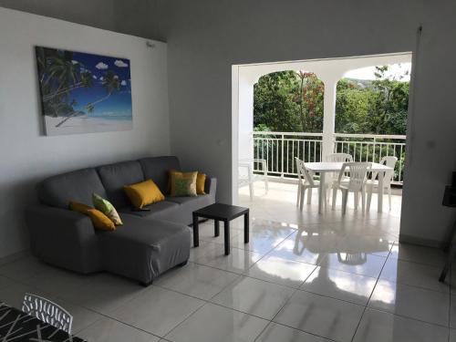 a living room with a couch and a table at villa vue sur mer in Deshaies